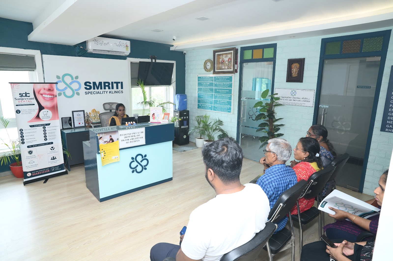 Reception with Sanjeevani Dental banner and waiting patients